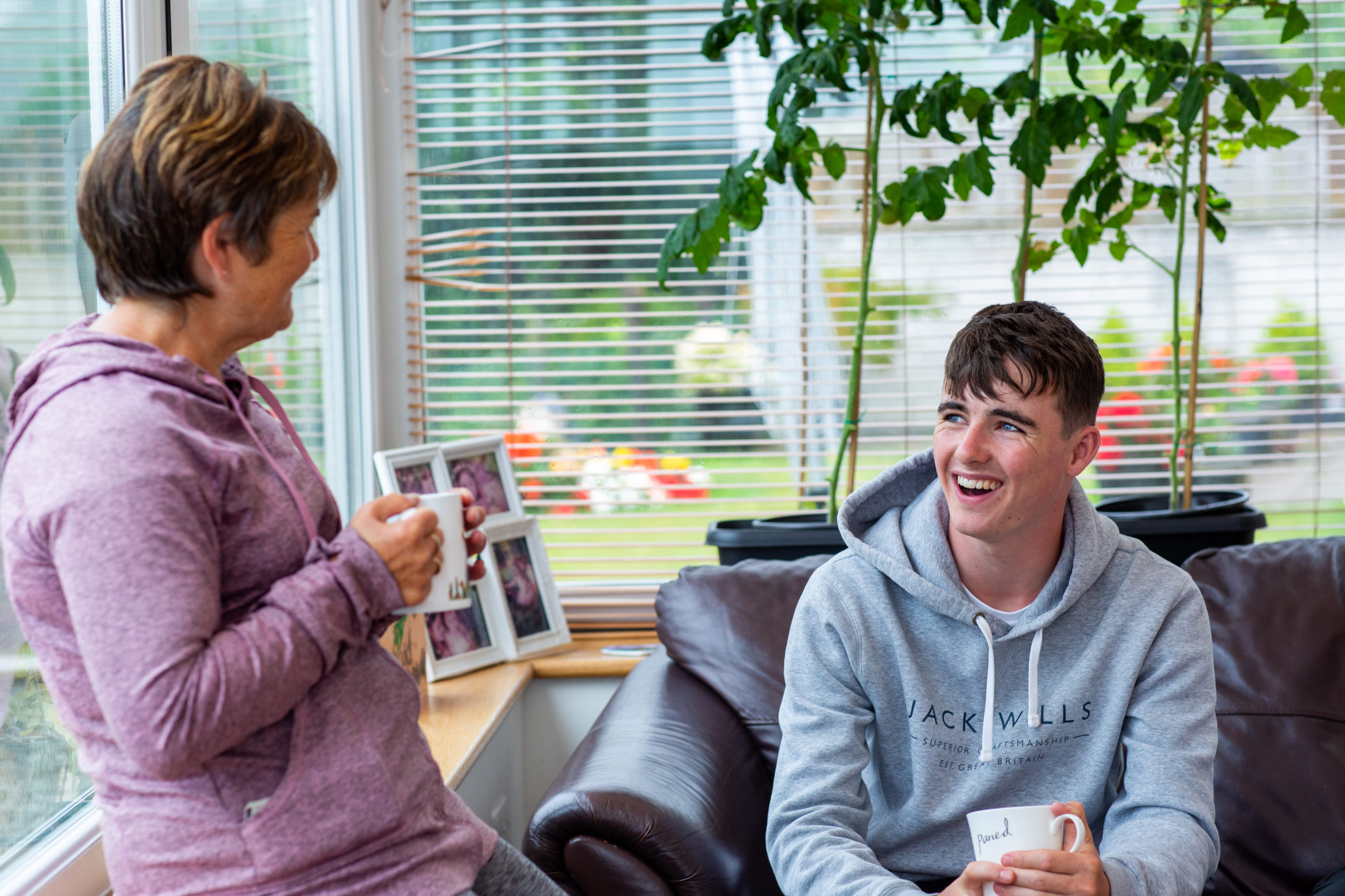 woman and teenage boy talking with cuppa