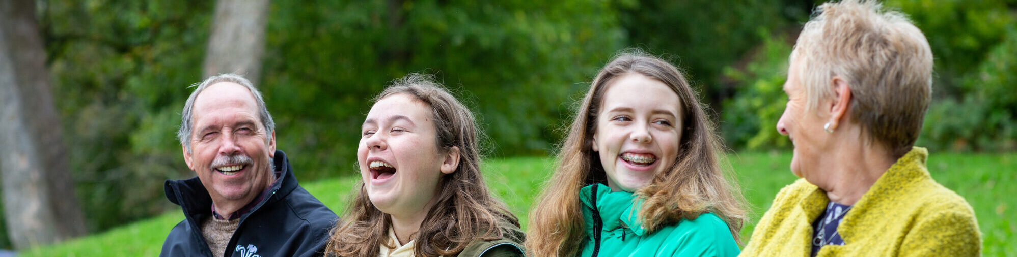 foster family sitting on bench and laughing