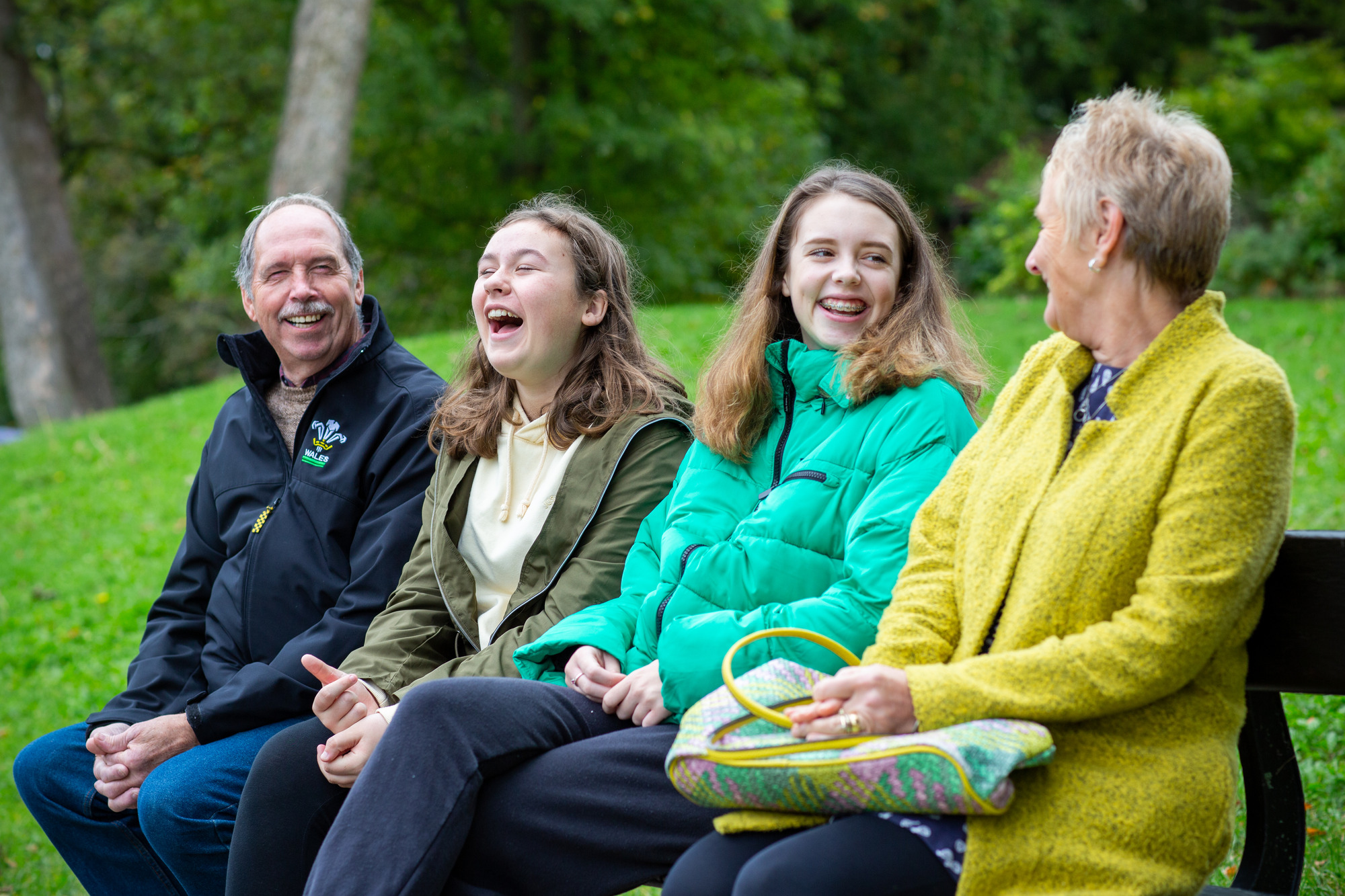 foster family sitting on bench and laughing